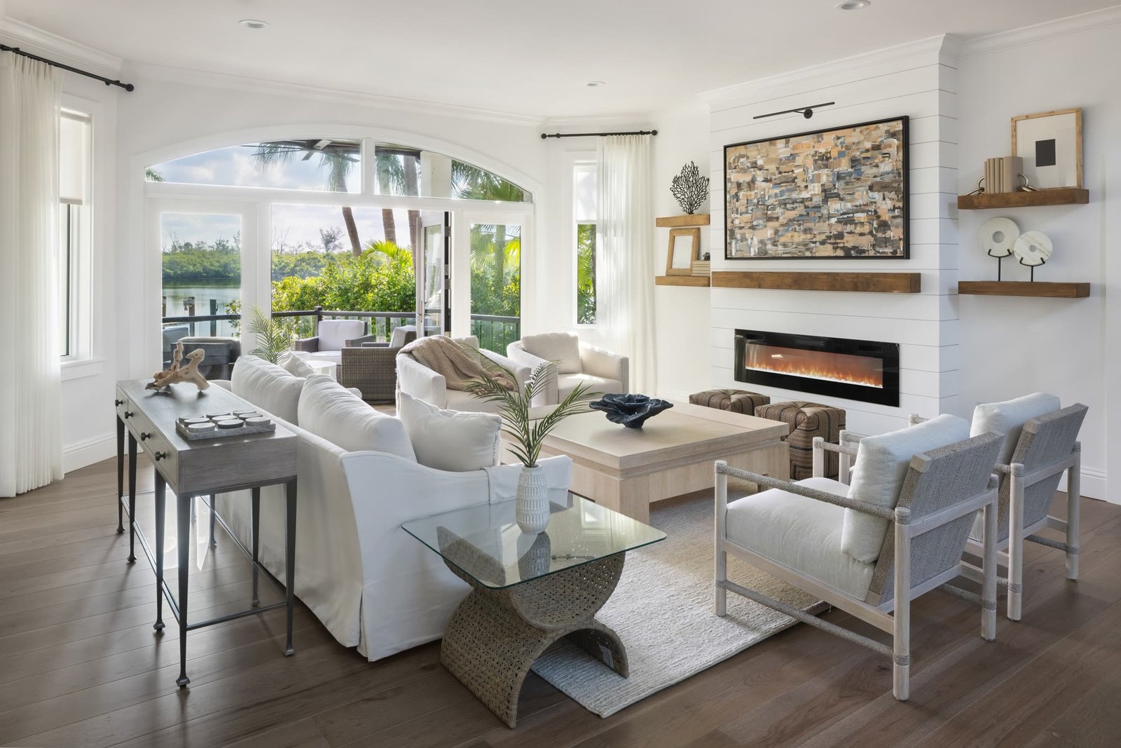 Waterfront living room with arched openings to the bay and a linear fireplace, St. Armands